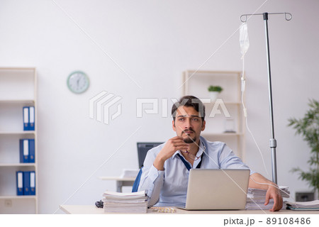 Young male employee suffering at workplace Young male employee suffering at workplace 89108486