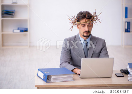 Young male employee wearing prickly wreath on head Young male employee wearing prickly wreath on head 89108487