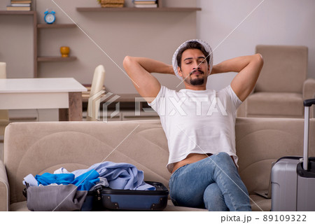 Young man preparing for trip at home Young man preparing for trip at home 89109322
