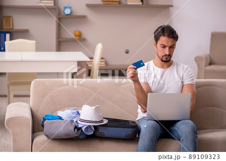 Young man preparing for trip at home Young man preparing for trip at home 89109323