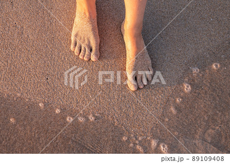 Beach - women's foot and the grains of sand. 89109408