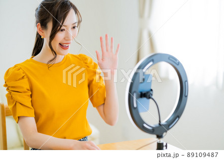 動画配信でフォロワーに手を振る20代女性 89109487