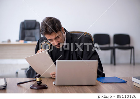 Young male judge working in the courthouse Young male judge working in the courthouse 89110126