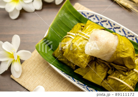 Thai dessert concept, Khao tom mat made from bananas with sticky rice in plate on wooden table 89111172