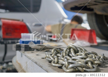 Chain lies on the mechanic's desk in the auto repair shop Chain lies on the mechanic's desk in the auto repair shop 89111312