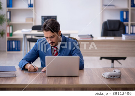 Young male employee working in the office Young male employee working in the office 89112406