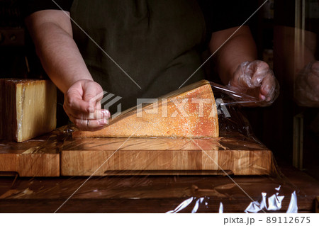 Piece of cheese is packed on counter. Piece of cheese is packed on counter. 89112675