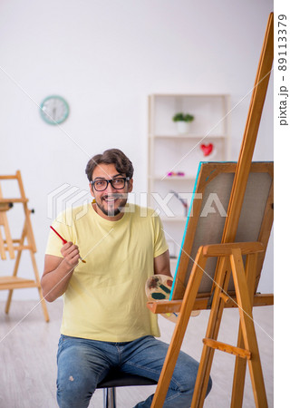 Young man enjoying painting at home Young man enjoying painting at home 89113379