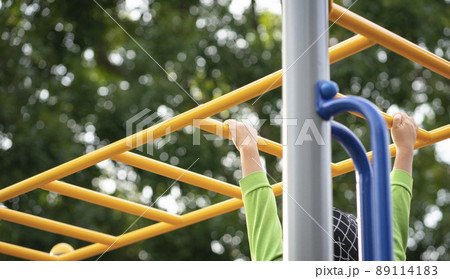 Kid playing on a children playground equipment. 89114183