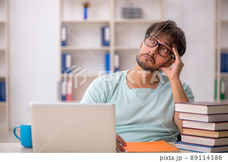 Young male student preparing for exams in the classroom 89114386