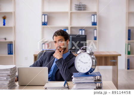 Young male employee in time management concept 89114458