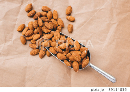 Raw almonds in a metal scoop. Selective focus 89114856