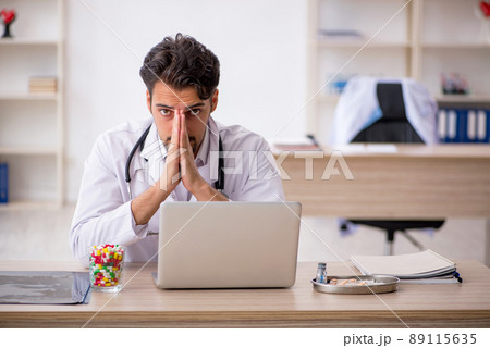 Young male doctor working in the clinic Young male doctor working in the clinic 89115635