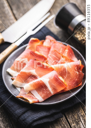 Sliced schwarzwald ham. Dried prosciutto ham on plate. 89116355