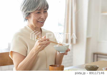 朝食をとる笑顔の50代女性 89117146