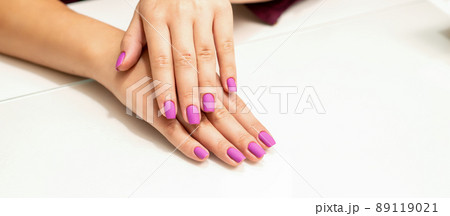 Beautiful manicure with purple, pink nail polish on young caucasian female hands Beautiful manicure with purple, pink nail polish on young caucasian female hands 89119021