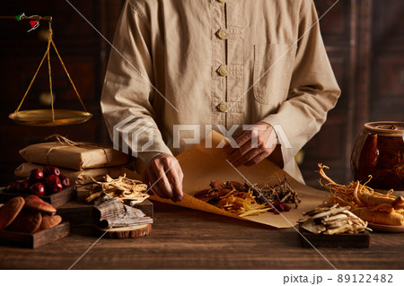 Front view of apocathery is wrapping herb with chinese traditional medicine in wooden table  89122482