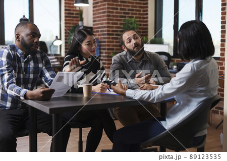 Multiethnic executive managers interviewing african american applicant discussing cv resume recruiting employer for human resources job in startup company office. Concept of hiring process Multiethnic executive managers interviewing african american applicant discussing cv resume recruiting employer for human resources job in startup company office. Concept of hiring process 89123535