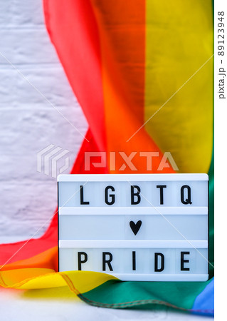 Rainbow flag with lightbox and text LGBTQ PRIDE. Rainbow lgbtq flag made from silk material. Symbol of LGBTQ pride month. Equal rights. Peace and freedom 89123948