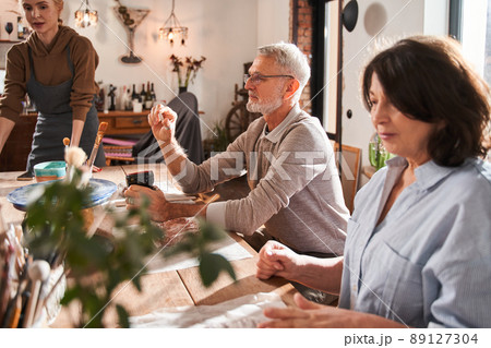 Senior people sitting at the table during the master class of the pottery 89127304