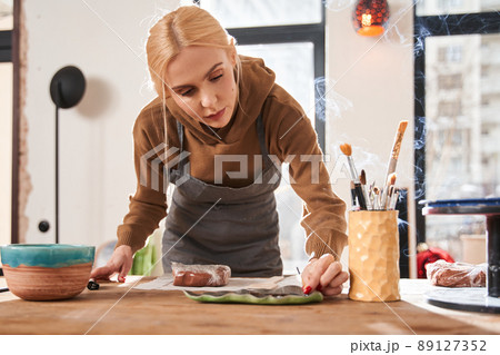 Female artist putting aroma stick at the special rack while creating atmosphere 89127352