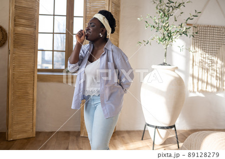 African american woman doing make up and looking involved 89128279