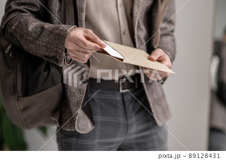 A young man in stylish jacket reading papers A young man in stylish jacket reading papers 89128431
