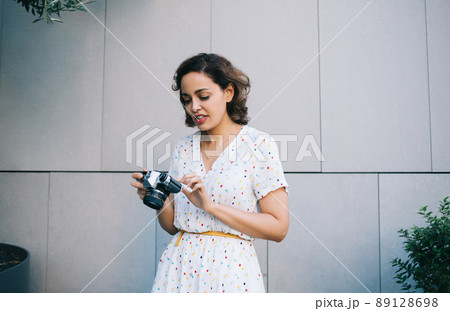 Pensive woman with camera on street 89128698