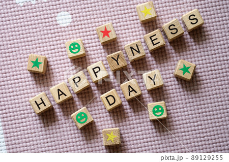 Word sHappiness day is written in wooden cubes among stars and smiles closeup 89129255