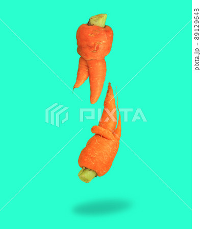 Ugly food. Deformed carrots on trendy aqua turquoise background.Food waste problem concept.Minimal flatlay,pop art style Ugly food. Deformed carrots on trendy aqua turquoise background.Food waste problem concept.Minimal flatlay,pop art style 89129643