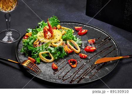 Asian style salad of greens with fried squid, shrimps, mussels and pineapple Asian style salad of greens with fried squid, shrimps, mussels and pineapple 89130910