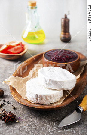 Camembert cheese with figs, raspberry jam. Round brie or camambert cheese on cutting board Camembert cheese with figs, raspberry jam. Round brie or camambert cheese on cutting board 89136212
