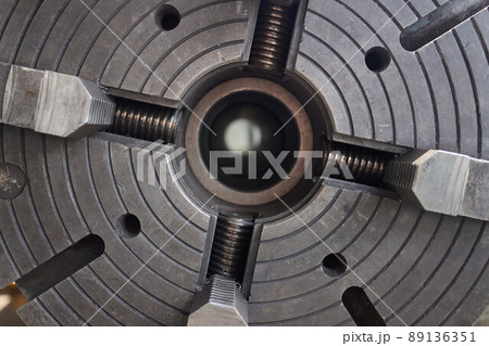 Close up of the CNC lathe jaw clamping raw material steel rod .Steel Cylinder part after turning process. Hi-precision CNC machining concept.Raw material steel rod for CNC lathe precess. 89136351