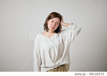 頭痛がして手で頭をおさえる若い女性 89136555