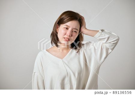 頭痛がして手で頭をおさえる若い女性 89136556