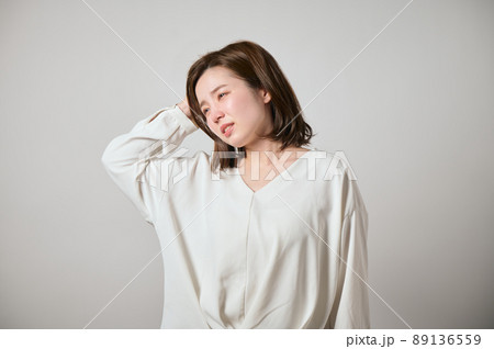 頭痛がして手で頭をおさえる若い女性 89136559