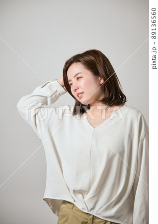 頭痛がして手で頭をおさえる若い女性 89136560