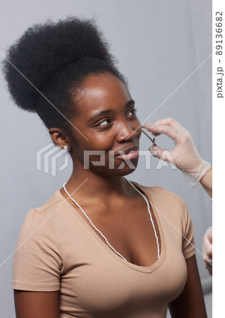 Close up of woman's ear with pierced on her ear for treatment of the pain some place on her body by Chinese doctor. 89136682