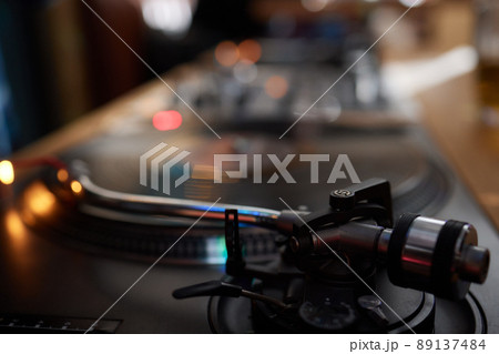 Vinyl record player, bright lights disco-bokeh. Needle on vinyl record. Vinyl record player, bright lights disco-bokeh. Needle on vinyl record. 89137484