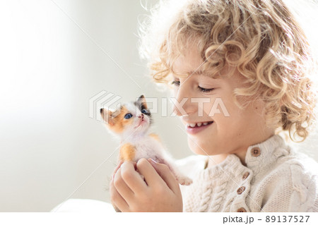 Child playing with kitten. Cat and kid at home. Child playing with kitten. Cat and kid at home. 89137527