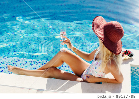 sexy woman relax in swimming pool and drinks champagne 89137788