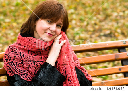stylish attractive young smiling woman walking down the street in autumn outfit, red knitted scarf, happy mood, fashion style. 89138032