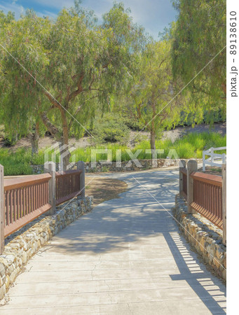 Vertical Whispy white clouds Concrete walkway in the middle of railings on a stone foundation 89138610