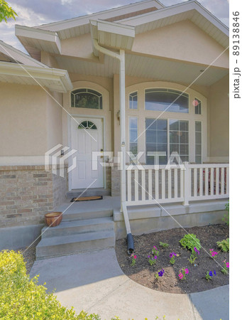 Vertical Puffy clouds at sunset Beige house exterior with attached garage and basement window 89138846