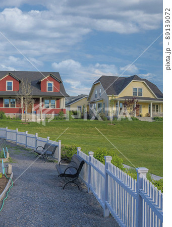 Vertical White puffy clouds Community garden with white picket fence in a residential area a Vertical White puffy clouds Community garden with white picket fence in a residential area a 89139072