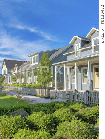 Vertical Whispy white clouds Lawn with bushes in the middle of two concrete sidewalks at a residential in Daybreak, Utah Vertical Whispy white clouds Lawn with bushes in the middle of two concrete sidewalks at a residential in Daybreak, Utah 89139452
