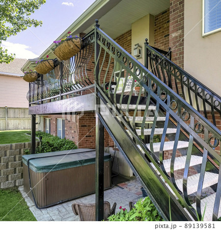 Square Home exterior with red bricks and staircase with metal railings 89139581