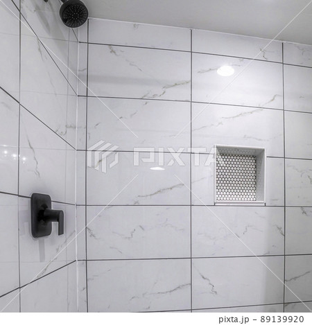 Square Shower stall with mosaic tiles flooring and marble tiles surround with black grout 89139920