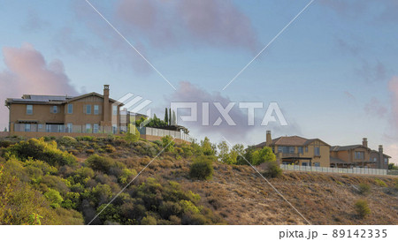 Panorama Puffy clouds at sunset Fenced large houses near the edge of a slope at San Marcos, Cali 89142335