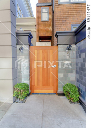 Wooden gate door with two bushes and wall lamps on both sides in San Francisco, California 89145477